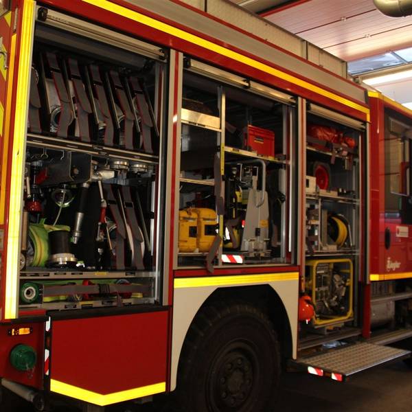 Ein Rüstwagen der Löschgruppe Heiligenhaus der Freiwilligen Feuerwehr in der Stadt Overath steht mit offenen Rolltüren in der Fahrzeughalle.