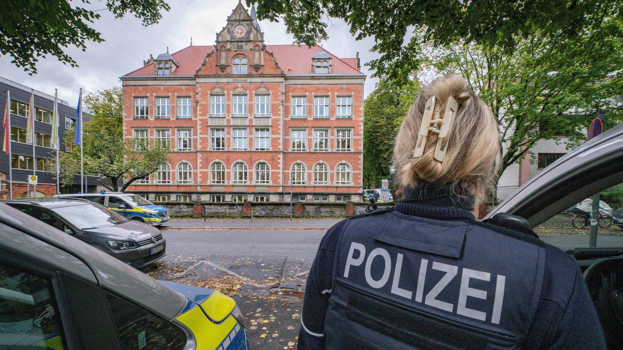 Polizisten vor einer Gesamtschule.