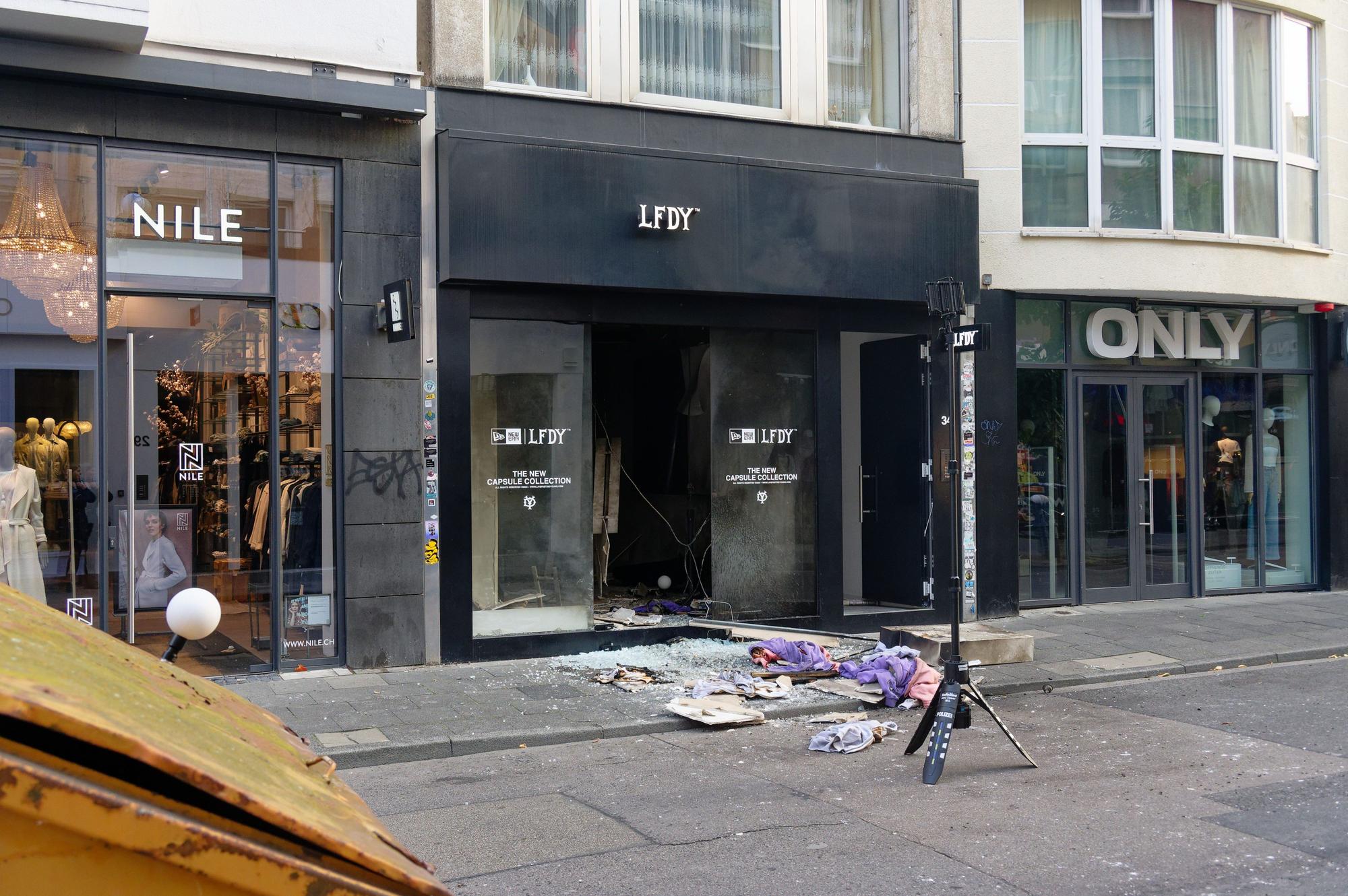Köln: Scherben und Kleidungstücke liegen vor einem Geschäft in der Ehrenstraße in Köln. Dort hatte es eine Explosion gegeben, bei der die Ermittler einen Bezug zu niederländischen Drogenbanden sehen.