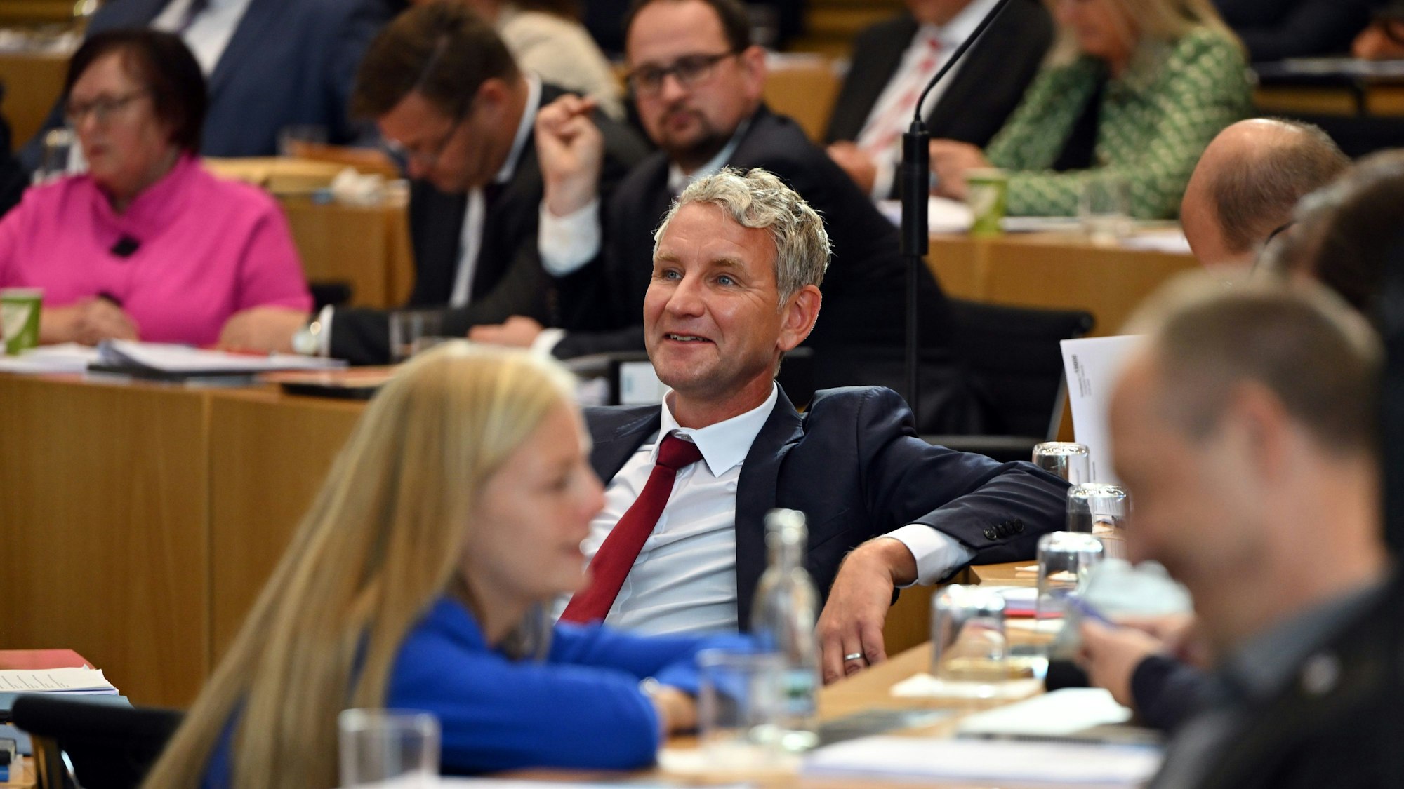 Björn Höcke, Thüringer AfD-Fraktionschef, sitzt während der konstituierenden Sitzung lächelnd im Landtag.dpa