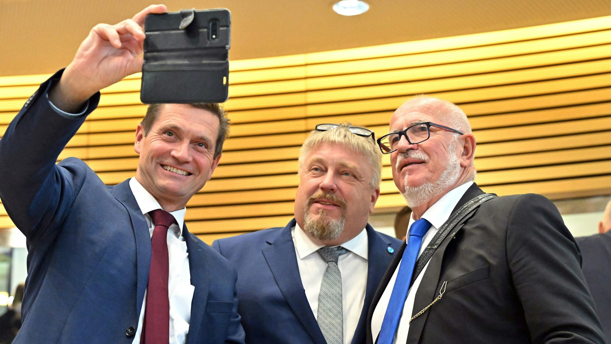 Die AfD-Abgeordneten Uwe Thrum (von links), Jan Abicht und Jürgen Treutler, AfD-Abgeordneter und Alterspräsident, machen ein Selfie nach der Unterbrechung der konstituierenden Sitzung des Landtags.