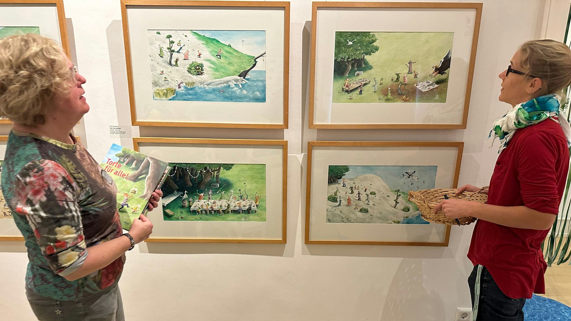 Ausstellung mit Werken von Thé Tjong-Khing im Bilderbuchmusem auf Burg Wissem. Museumsleiterin Dr. Pauline Liesen (links) mit Mitarbeiterin Anne Kleine (r.), beide sind Kuratoren der Ausstellung, vor einer Auswahl von Zeichnungen.