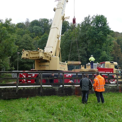 Ein Autokran steht hinter Teilen einer Brücke.