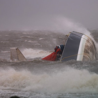 Ein Boot liegt im Wasser und wird von Fluten überspült.