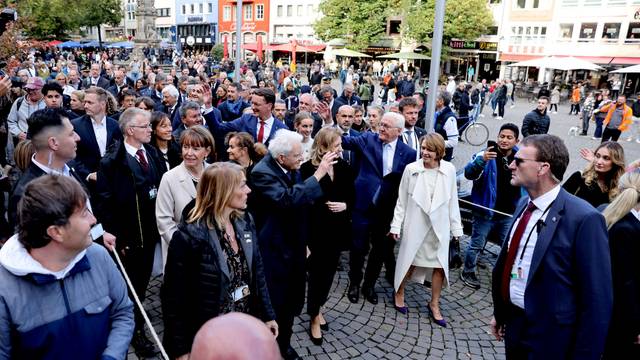 Italiens Staatspräsident Sergio Mattarella (M.) winkt vor dem Kölner Rathaus den Schaulustigen.