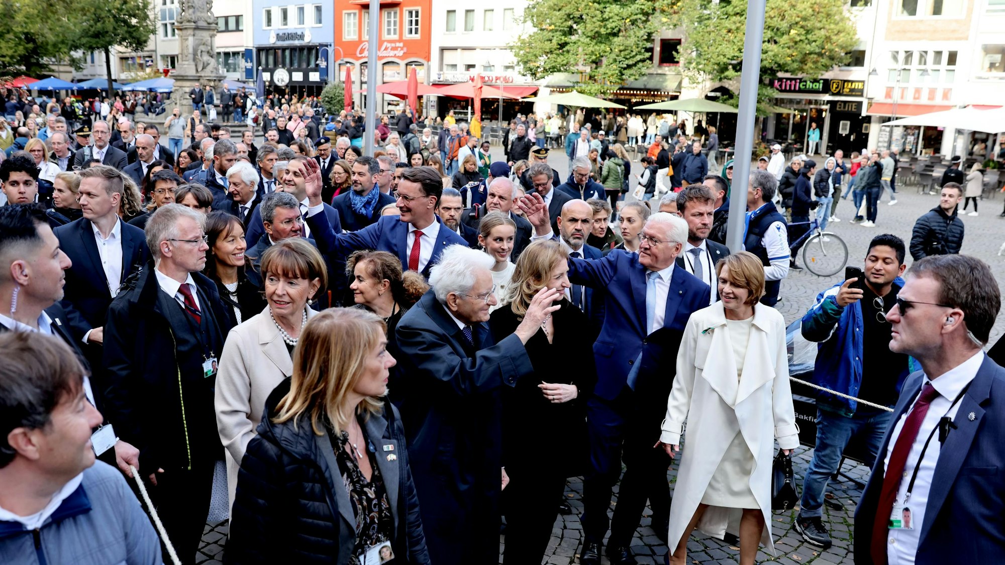 Italiens Staatspräsident Sergio Mattarella (M.) winkt vor dem Kölner Rathaus den Schaulustigen.