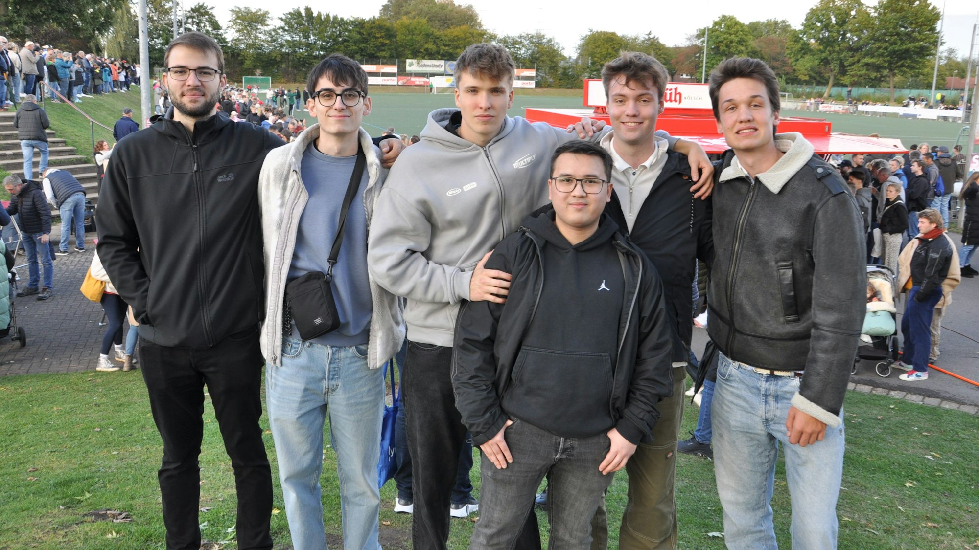 Sechs junge Männer schauen in die Kamera.