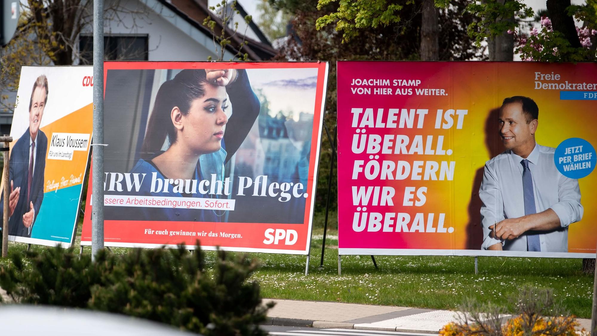 Mehrere große Wahlplakate von CDU, SPD und FDP zur Landtagswahl 2022 stehen nebeneinander.
