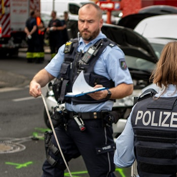 Das Bild zeigt eine Polizistin und einen Polizisten bei der Aufnahme eines Verkehrsunfalls in Euskirchen. Sie haben beide ein Maßband in der Hand.