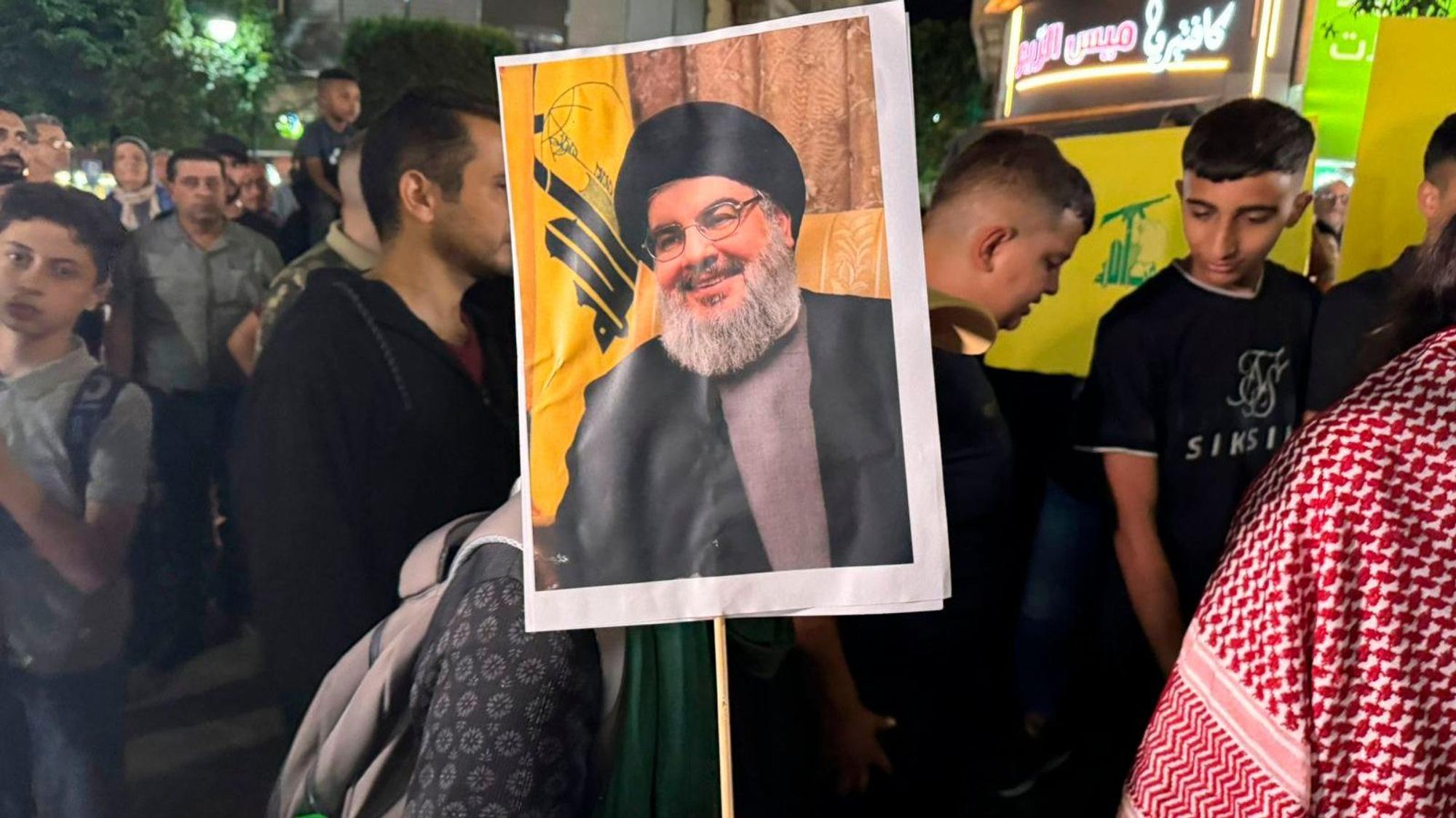 Palestinian protesters carry Hezbollah flags and posters with a picture of Hezbollah leader Sayyed Hassan Nasrallah during a rally in support of Hezbollah, in the West Bank city of Ramallah Saturday, Sept. 28, 2024. (AP Photo/Nasser Nasser)