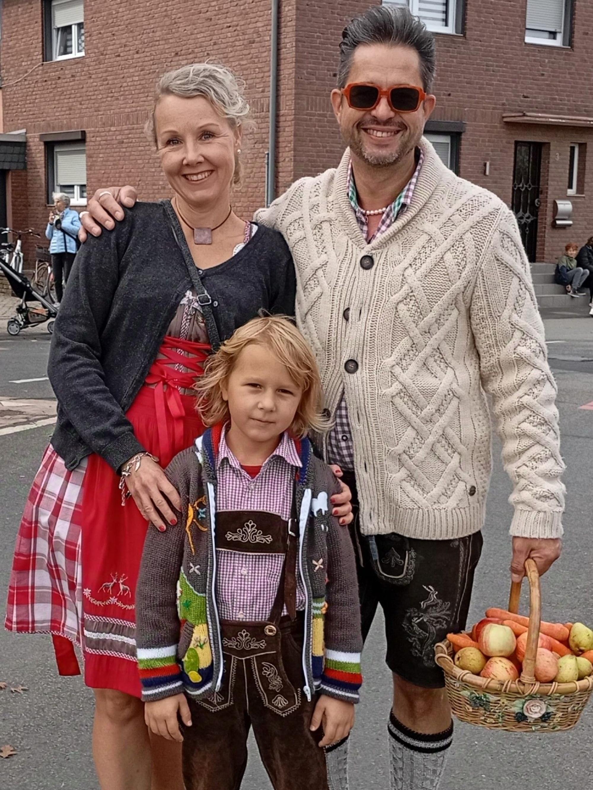 Das Bild zeigt festlich gekleidete Zuschauer am Straßenrand.
