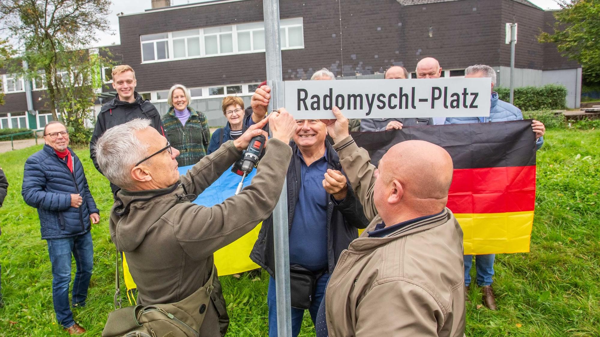 Gemeinsam befestigen Bürgermeister Georg Ludwig (l.) und sein ukrainischer Amtskollege Volodymyr Teterkyi das neue Straßenschild.