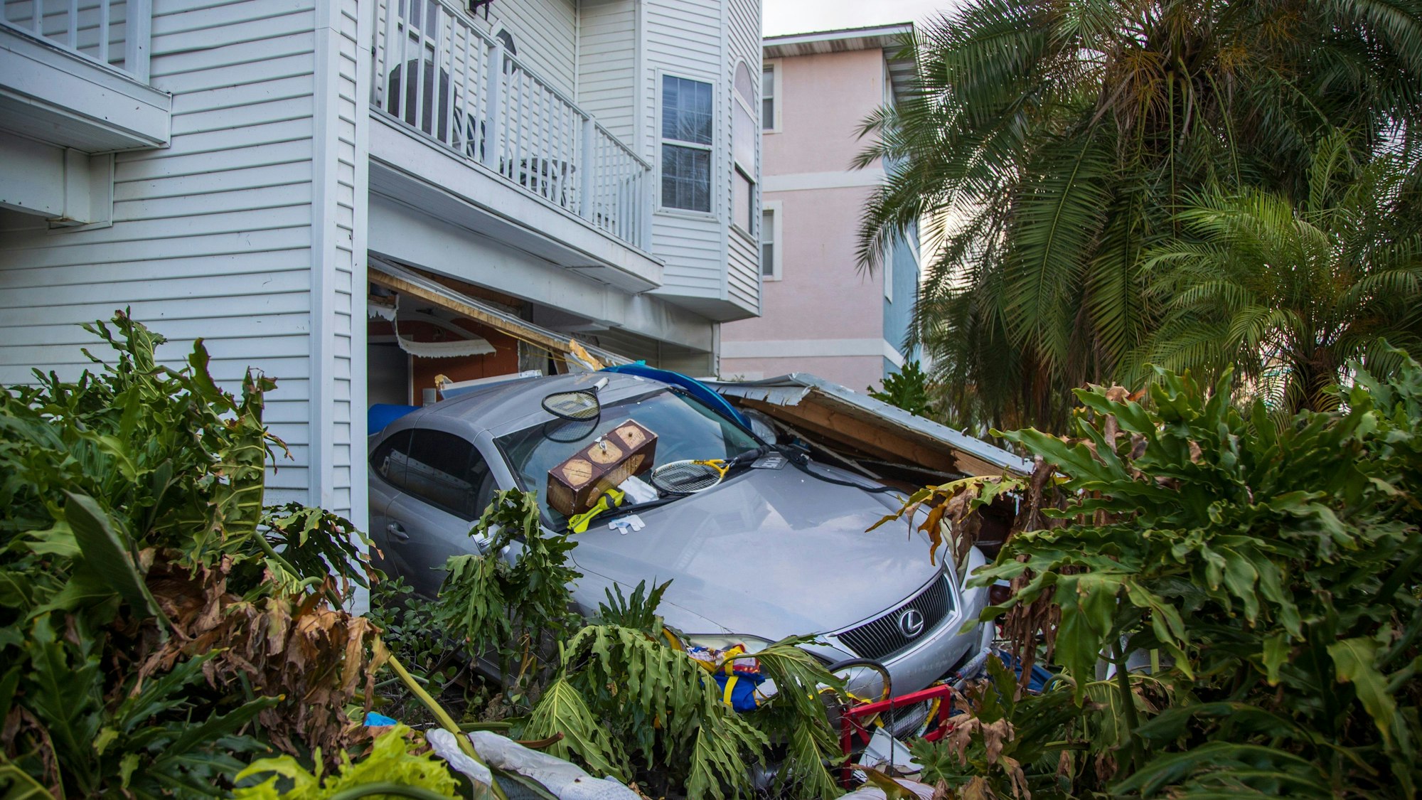 28.09.2024, USA, Madeira Beach: Ein Fahrzeug steht nach der Sturmflut des Hurrikans Helene in Madeira Beach, Florida, vor seiner Garage.