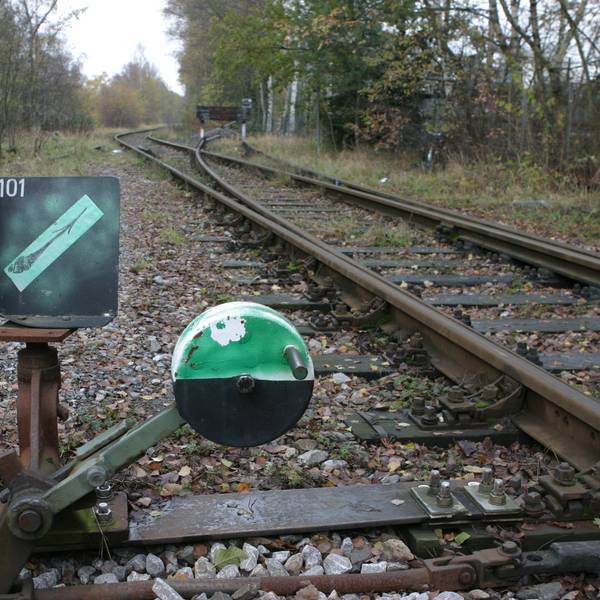 Grünes Zeichen vor den Gleisen des alten Bahndamms.