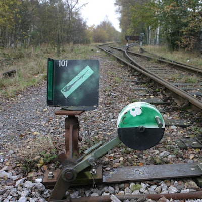 Grünes Zeichen vor den Gleisen des alten Bahndamms.