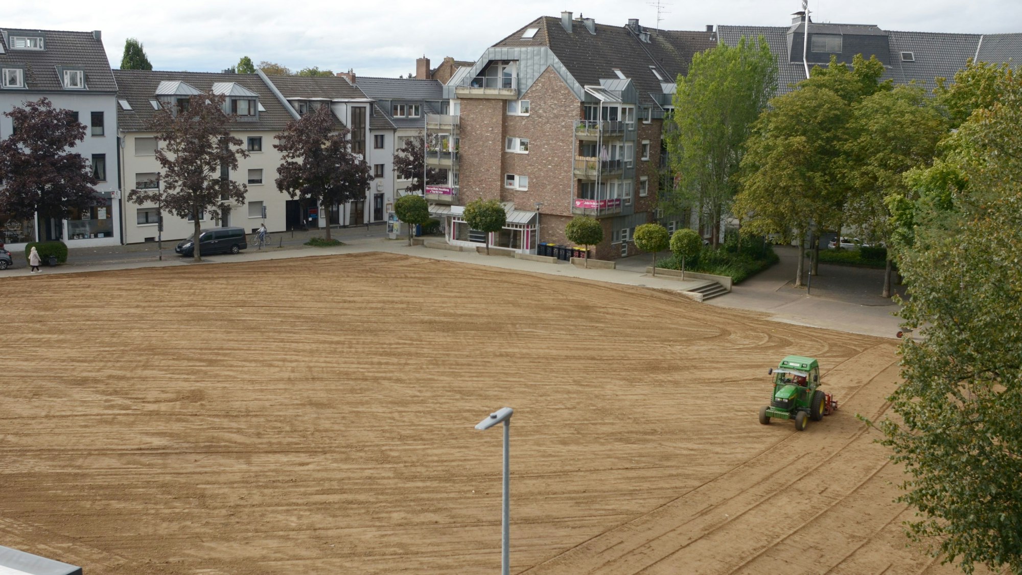 Ein Traktor glättet eine Brachfläche in der Innenstadt.