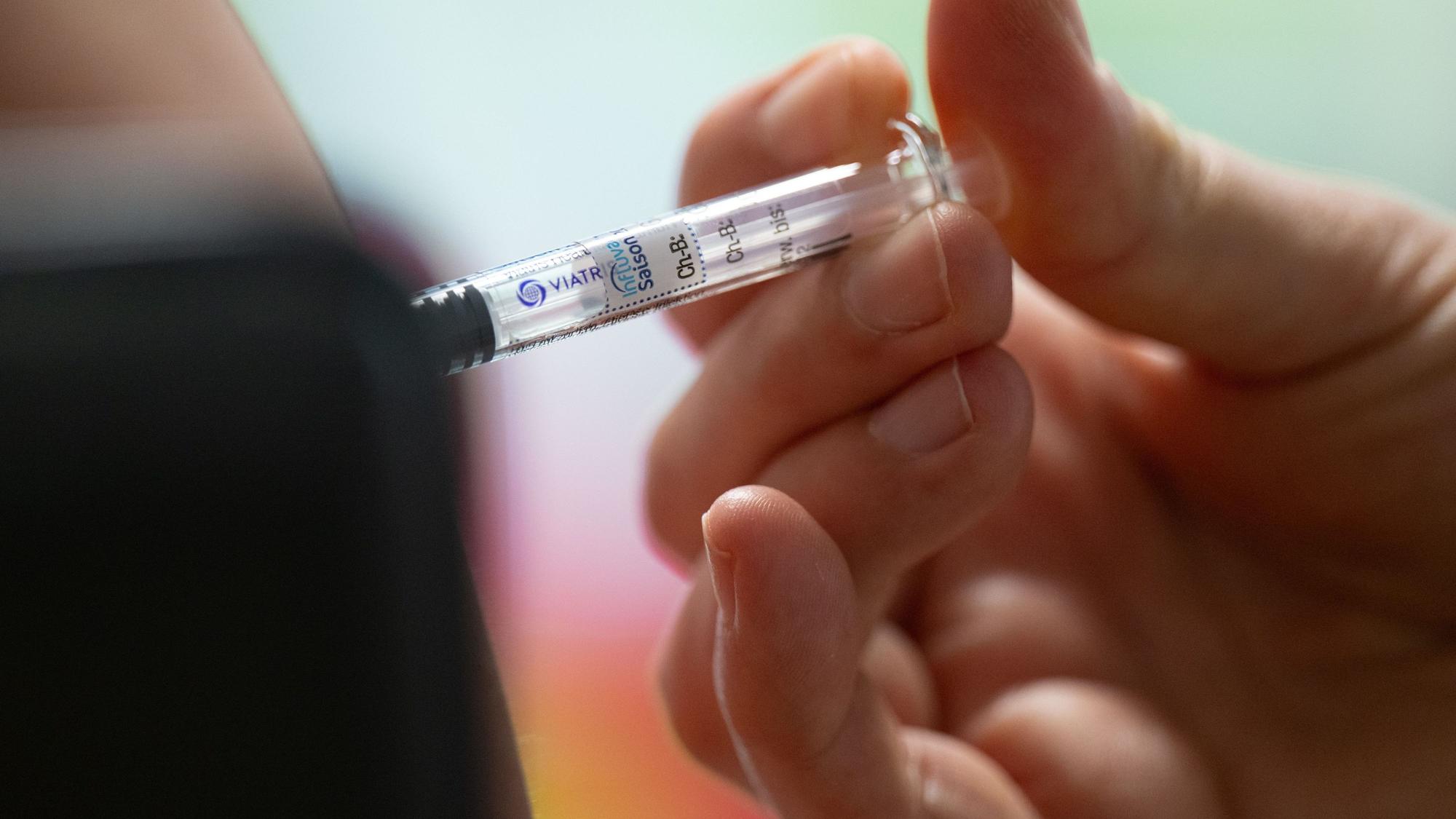 Eine Frau lässt sich während eines Pressetermins zur Grippeschutzimpfung mit dem saisonalen Wirkstoff gegen die
Grippe impfen.