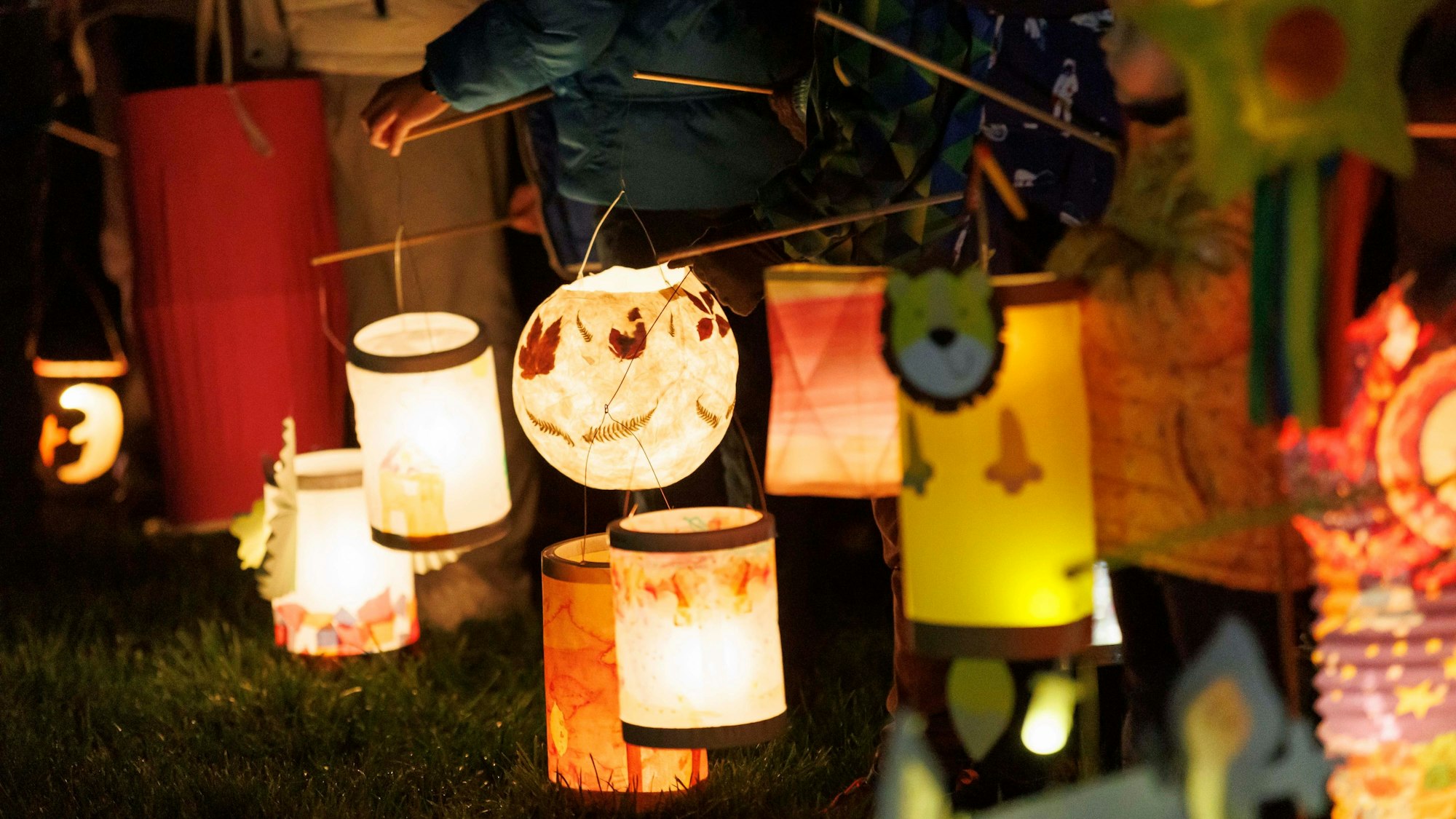 Kinder halten bei einem Martinsspiel ihre Laternen in der Hand.