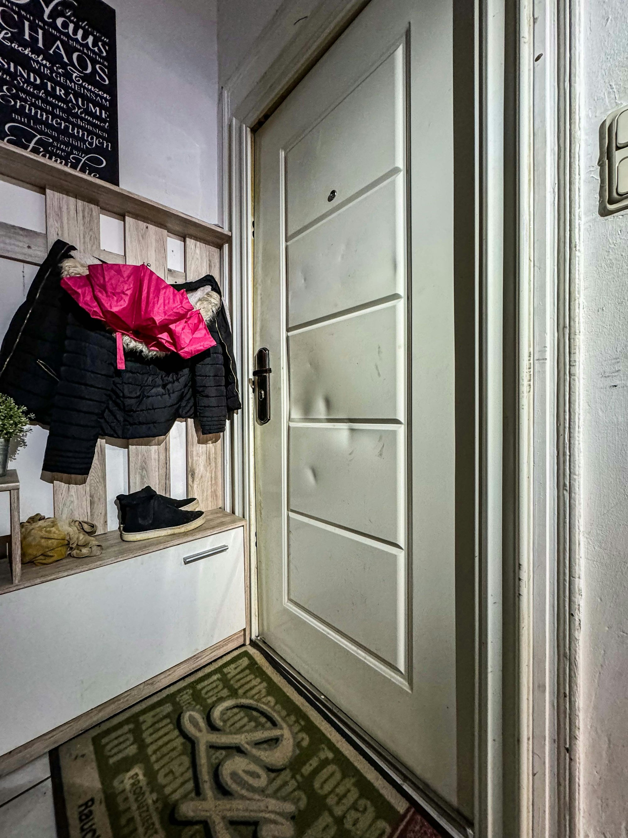 Bild einer geschlossenen Wohnungstüre, auf dem Türblatt sind deutliche Dellen zu sehen.