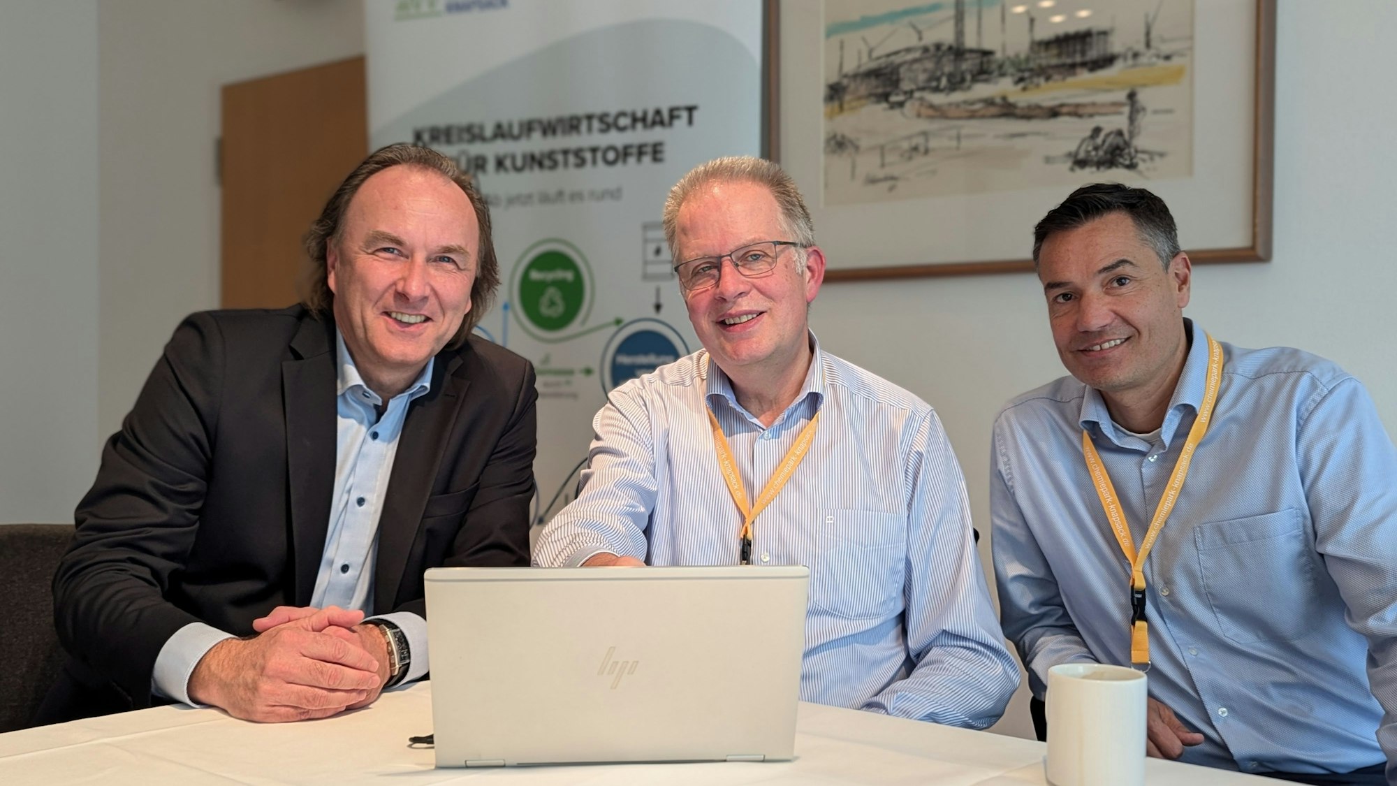 Das Foto zeigt drei Männer im Feierabendhaus hinter einem aufgeklappten Laptop.