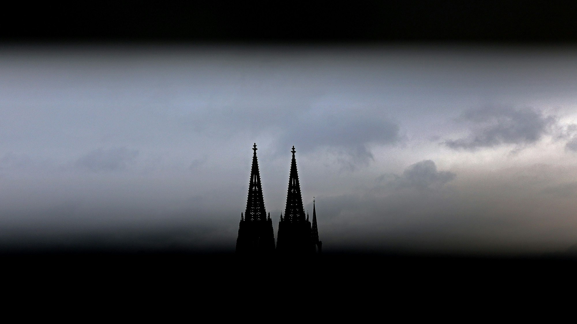 Nordrhein-Westfalen, Köln: ILLUSTRATION - Durch ein Geländer sind die Spitzen des Domes zu sehen.