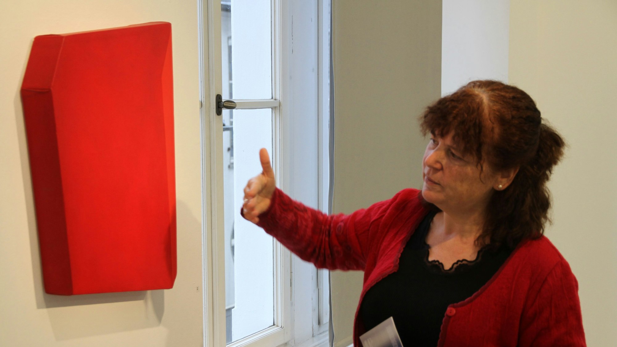 Eine Frau neben einem roten Kunstobjekt