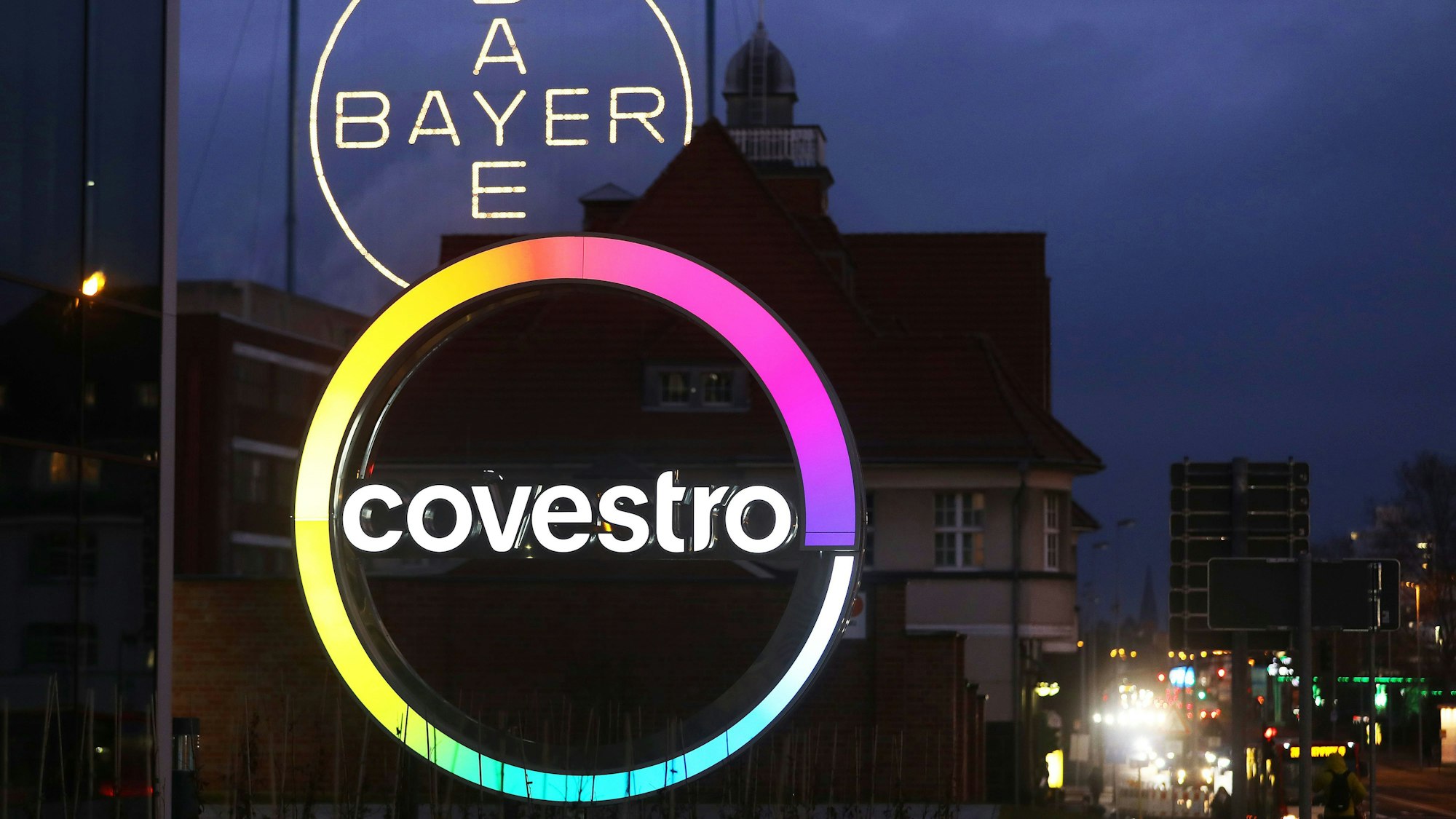Das Logo des Kunststoffkonzern Covestro leuchtet am Morgen vor der Unternehmenszentrale am Chempark Leverkusen.