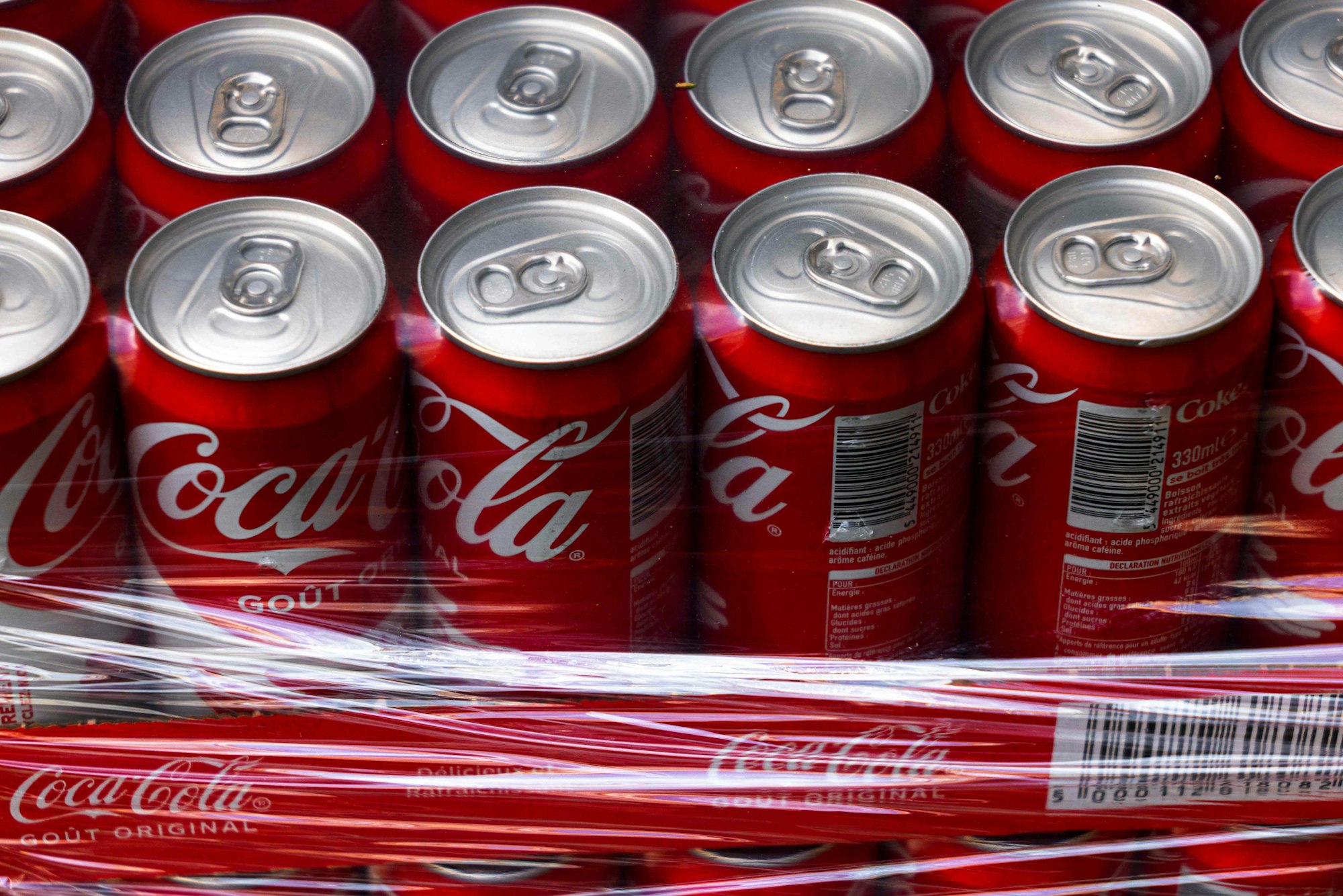Coca Cola Dosen stehen auf einer Platte