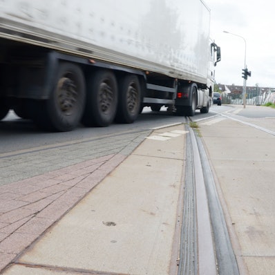 Ein Lastwagen, der den Pützbergring befährt, kreuzt die Gleisanlage.