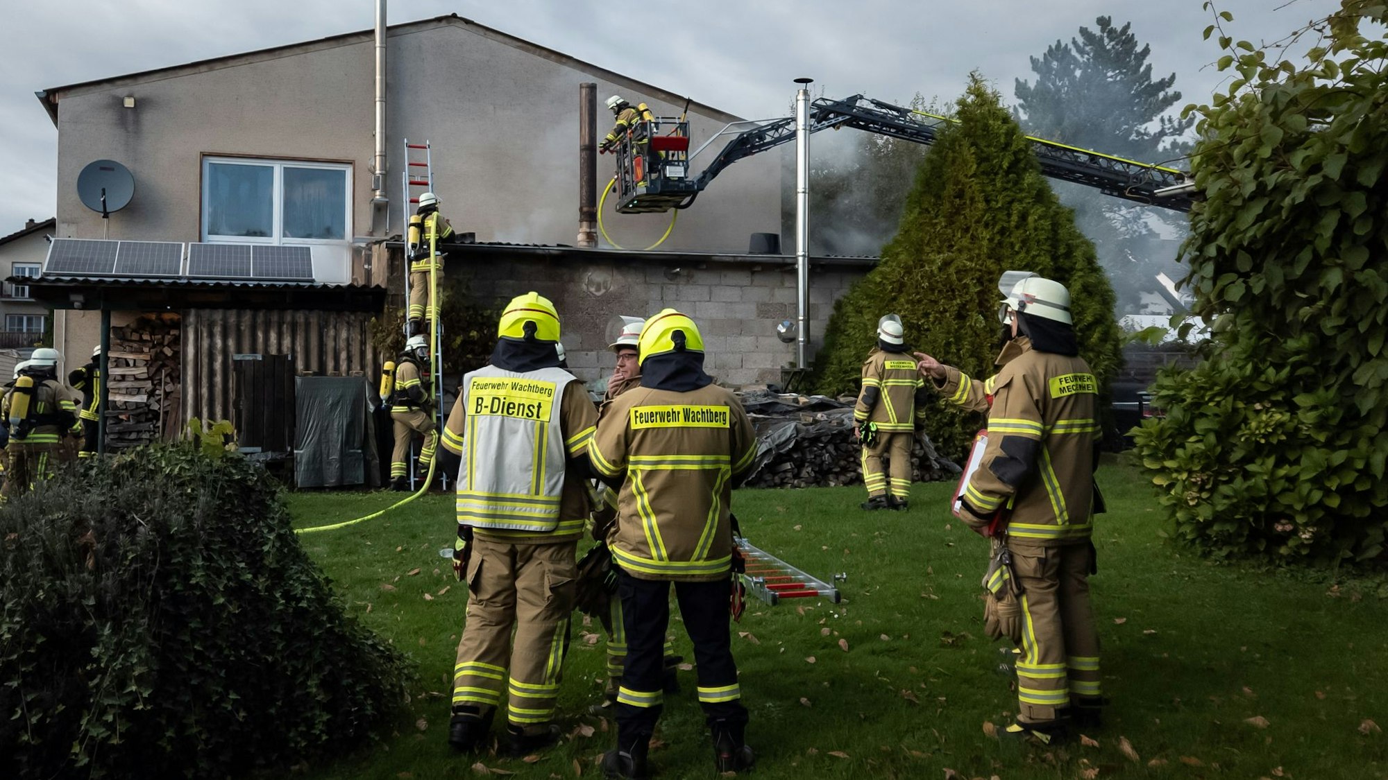 Feuerwehrleute stehen im Garten der Töpferei. Die Drehleiter ist im Einsatz.