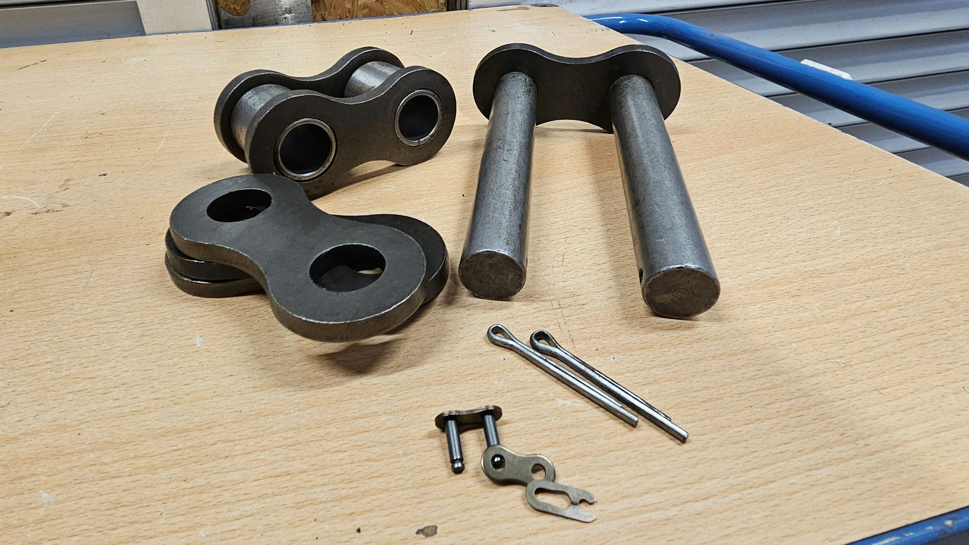 Blick auf ein großes und ein kleines Kettenglied, die auf einem Tisch liegen.