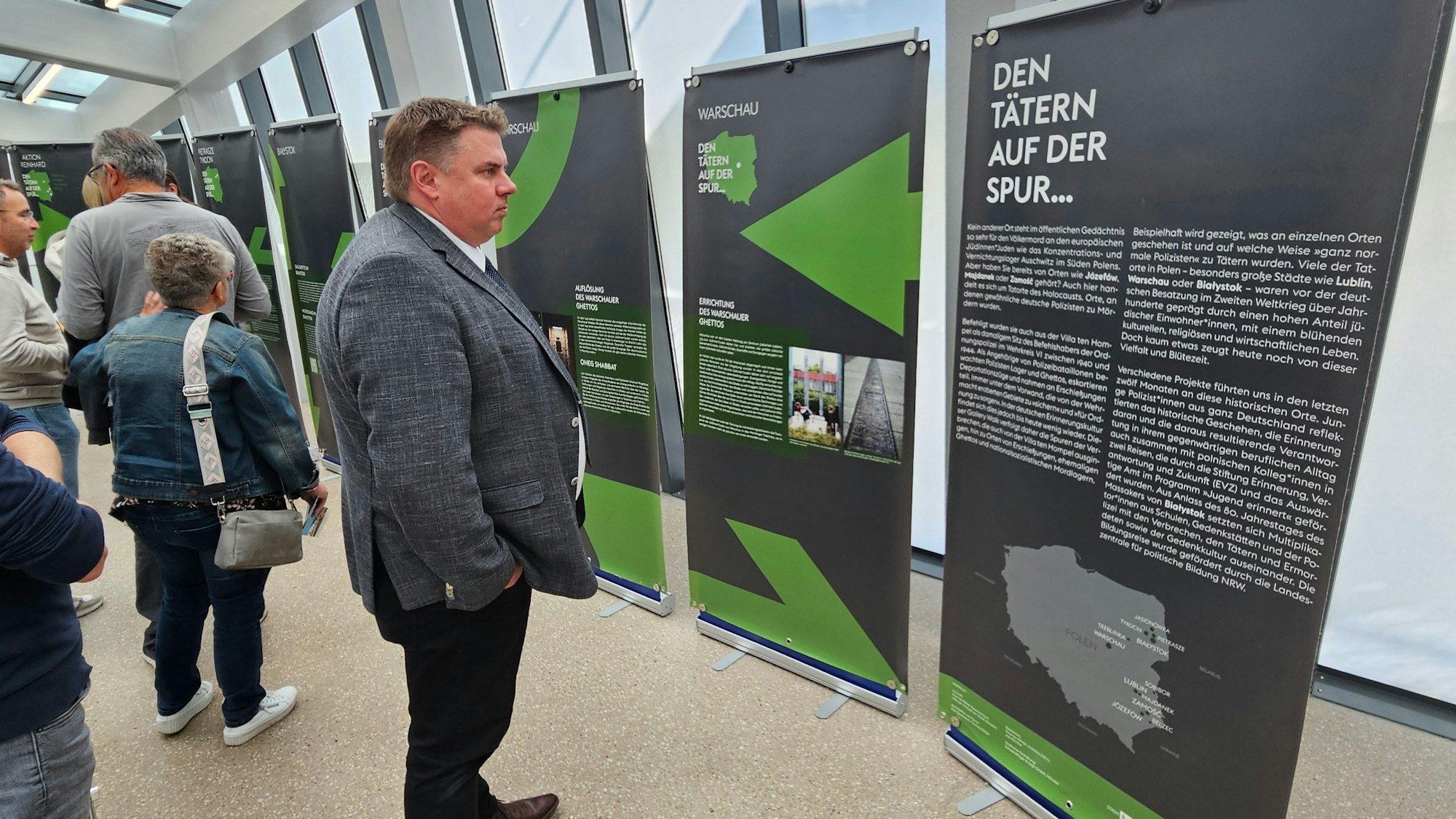 Besucher stehen vor den Aufstellern mit den Informationen der Ausstellung.