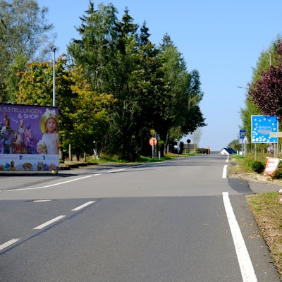 Am Grenzübergang Hergersberg bei Losheim weisen blaue Schilder mit der Aufschrift Belgien auf den Grenzverlauf hin.