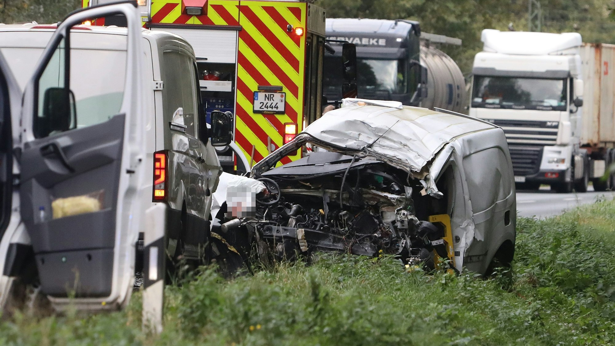 Ein Wagen liegt im Straßengraben, dessen Front völlig zerstört ist.