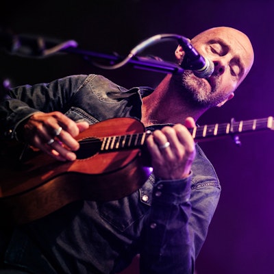 Ein Mann singt und spielt Mandoline.