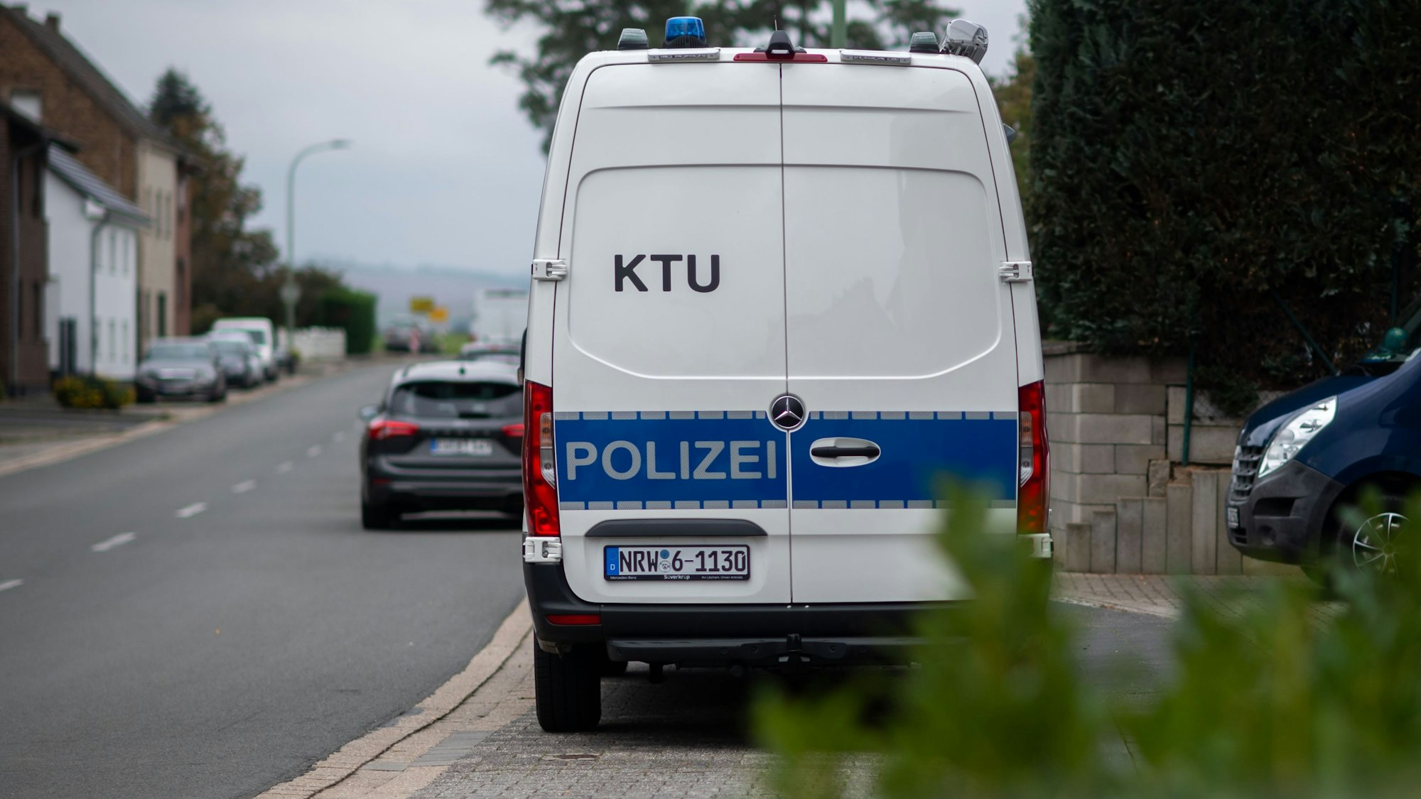 Ein weiß-blaues Fahrzeug der Polizei mit der Aufschrift KTU parkt an einer Straße in Zülpich-Füssenich.
