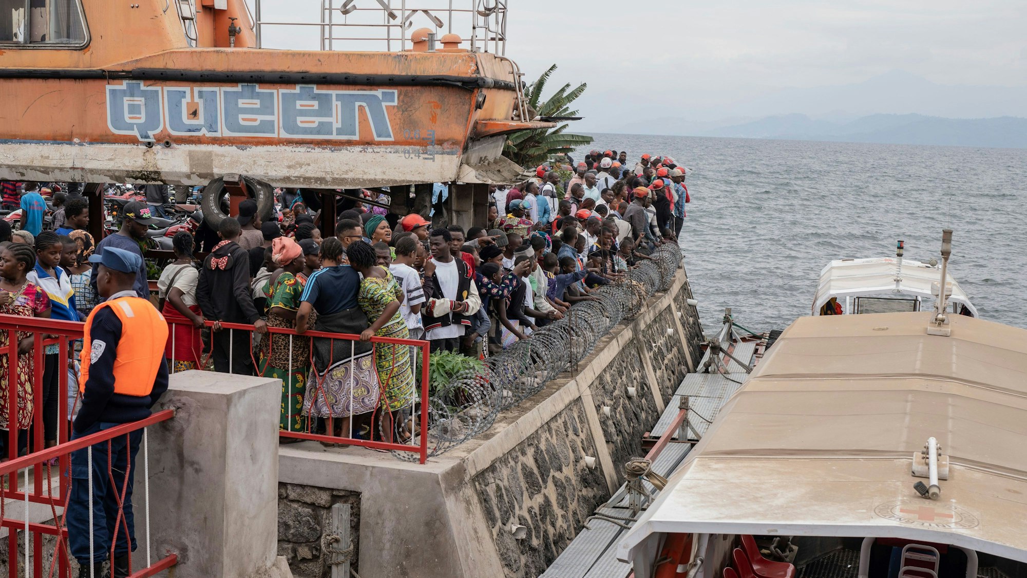 Menschen versammeln sich im Hafen von Goma, nachdem das Schiff bei der Ankunft gekentert ist.