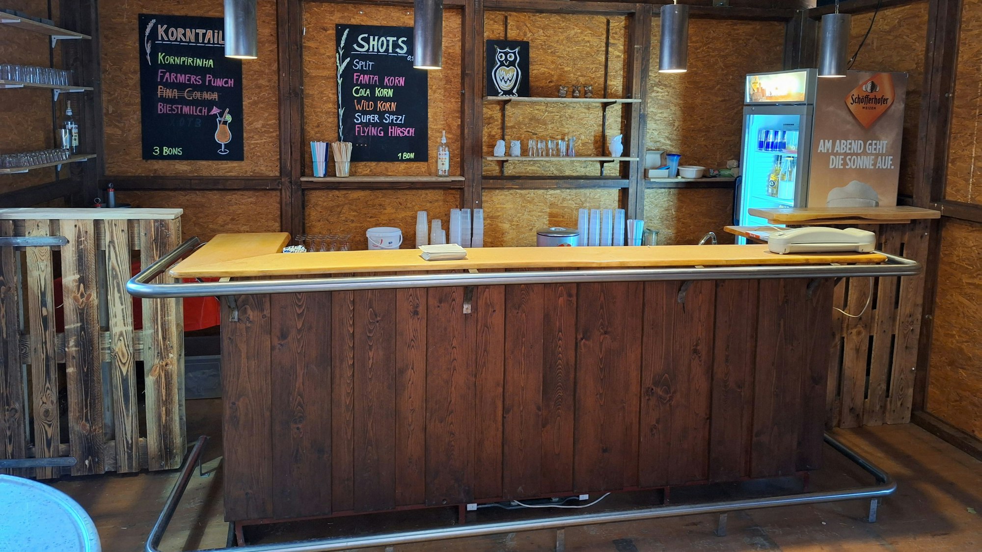 In einer Hütte steht eine Bar.