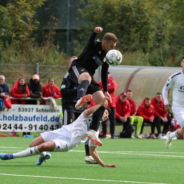 Einen spektakulären Zweikampf liefern sich Niclas Hampel im schwarzen Trikot und Marlon Große. Der Niefelder Spieler springt über seinen Zülpicher Kontrahenten.