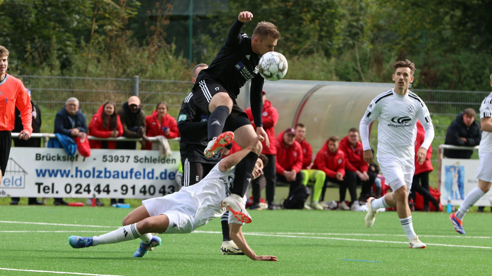 Einen spektakulären Zweikampf liefern sich Niclas Hampel im schwarzen Trikot und Marlon Große. Der Niefelder Spieler springt über seinen Zülpicher Kontrahenten.