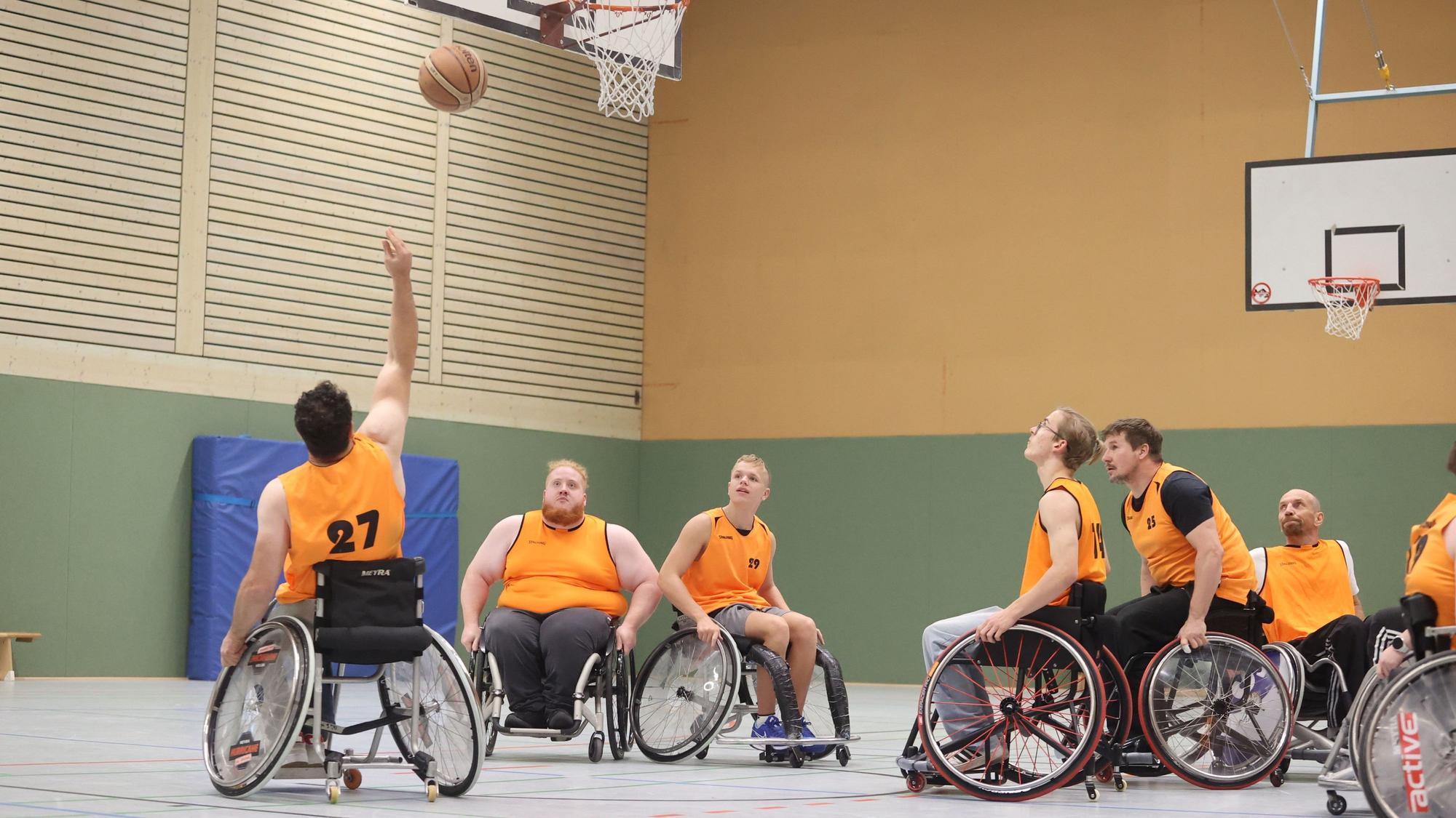Mehrere Rollstuhlbasketballer beim Training.