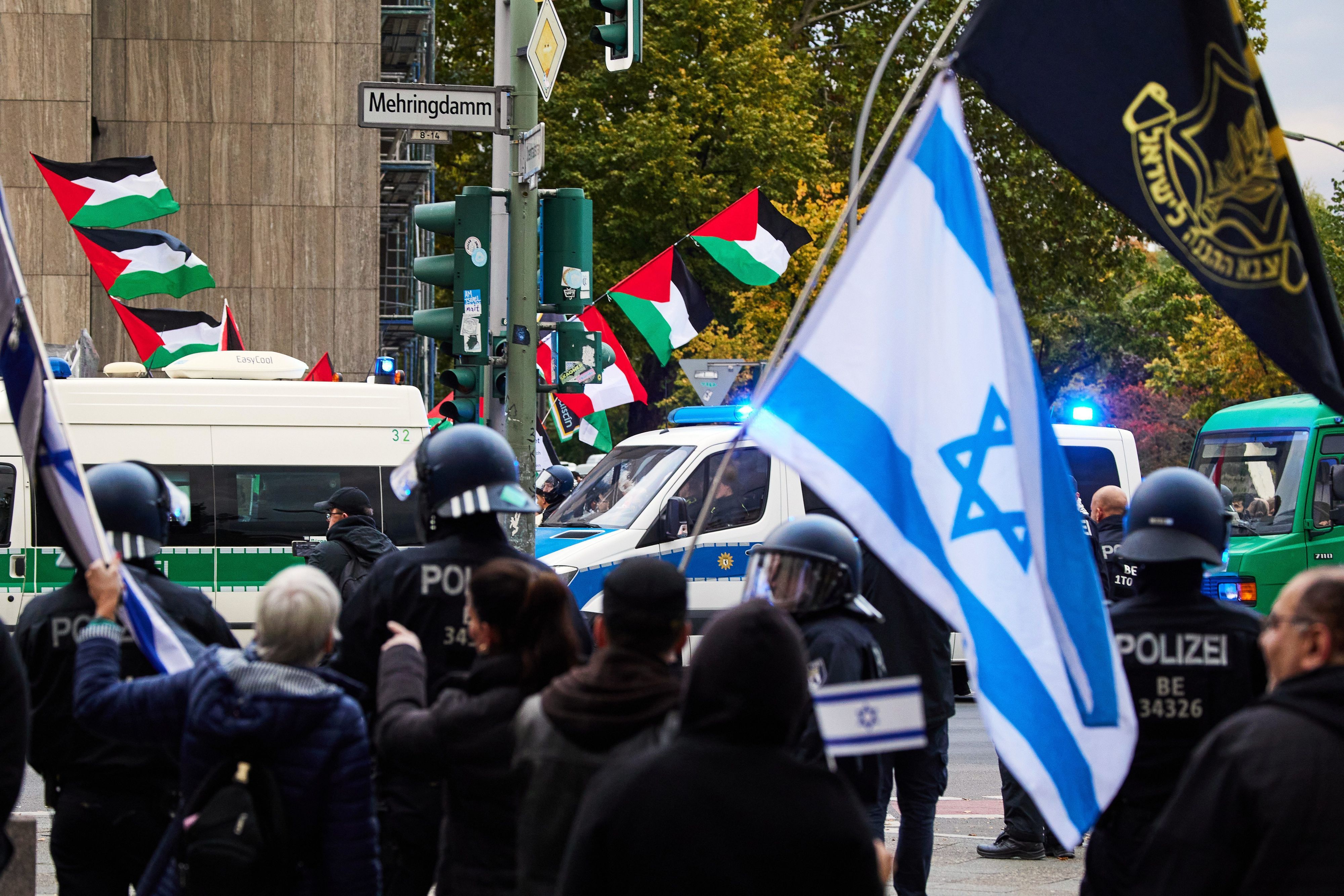 05.10.2024, Berlin: Teilnehmer einer proisraelischen Demonstration (vorne) als Gegenveranstaltung einer propalästinensischen Demonstration anlässlich des ersten Jahrestages des Überfalls der Hamas auf Israel halten an der Ecke Mehringdamm/Blücherstraße israelische Flaggen. Foto: Joerg Carstensen/dpa +++ dpa-Bildfunk +++