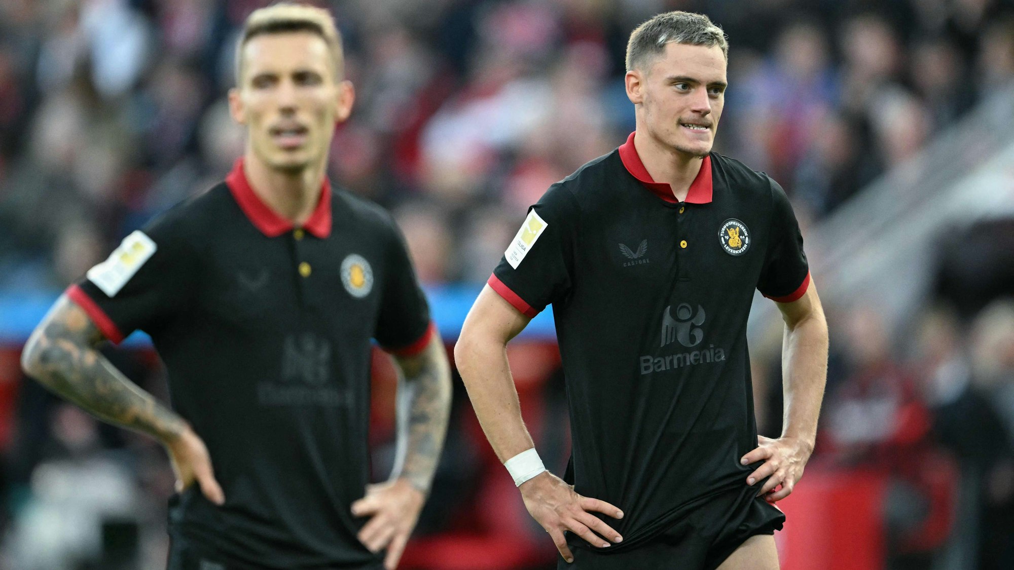 Bayer Leverkusens Florian Wirtz (R) und Alejandro Grimaldo ist die Enttäuschung über das 2:2 gegen KIel deutlich anzusehen.