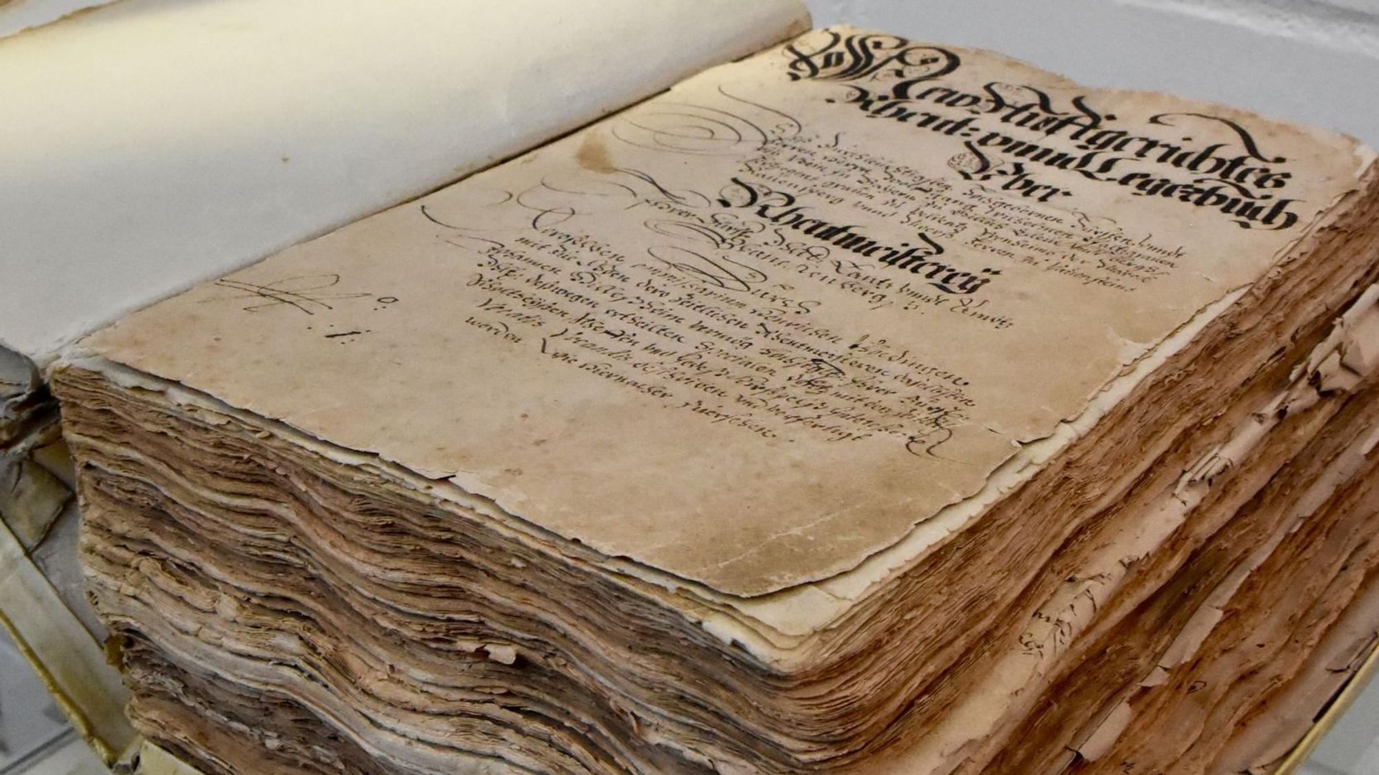 Ein dickes Buch mit vergilbten Seiten und alter Schrift.