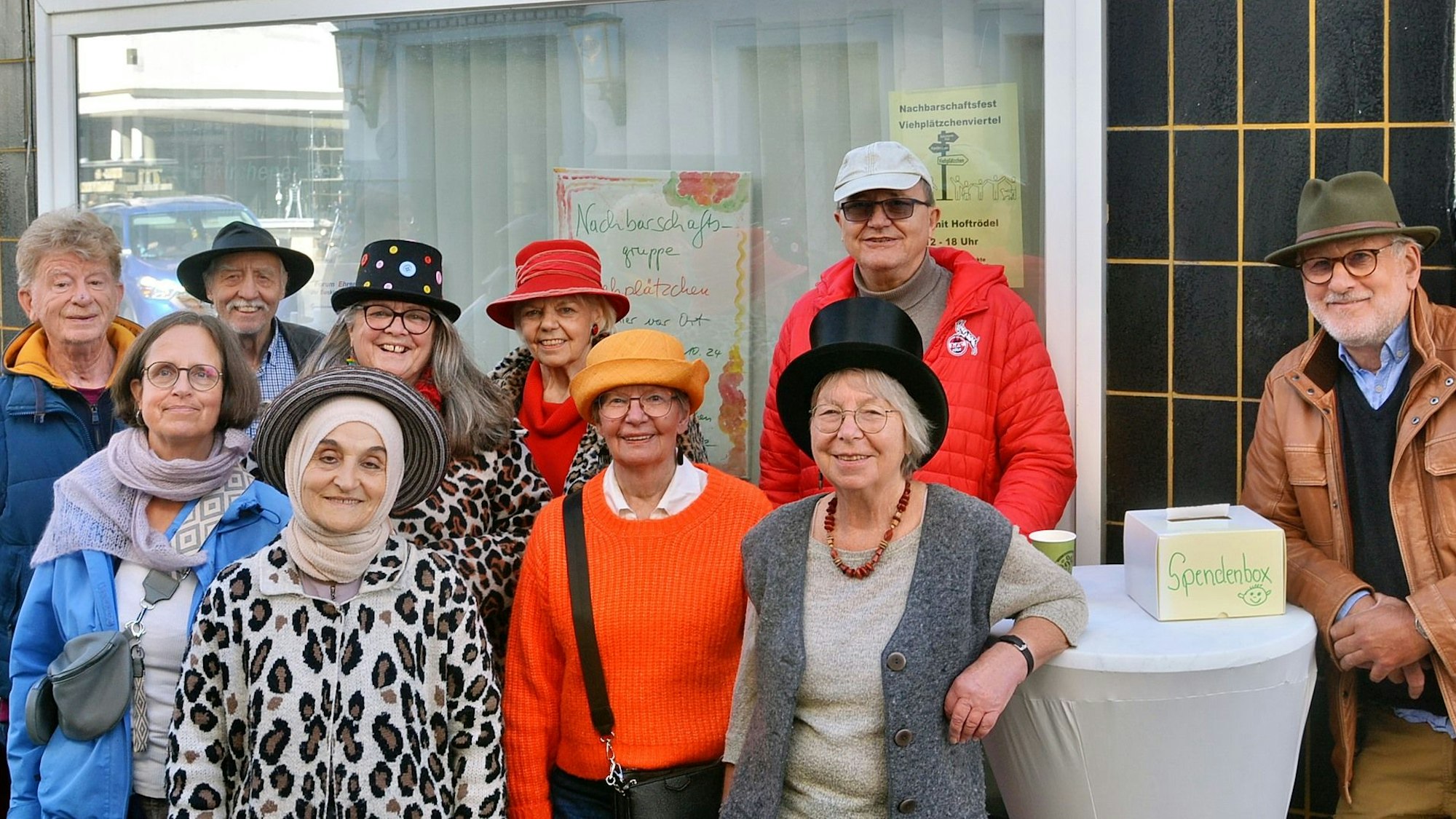 Eine Gruppe von Frauen und Männern steht vor einem Gebäude.
