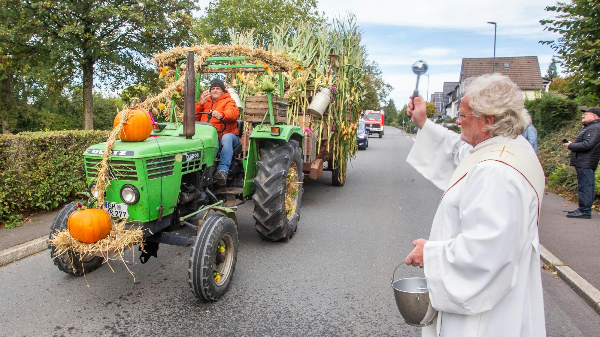 Ein Diakon spendet einem Erntewagen den Segen.