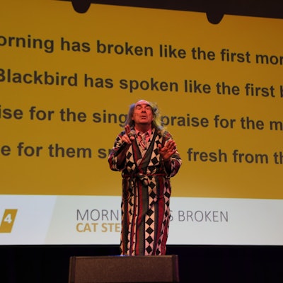 Guildo Horn auf der Bühne. Im Hintergrund wird auf einer Leinwand ein Liedtext eingeblendet, damit das Publikum mitsingen kann.