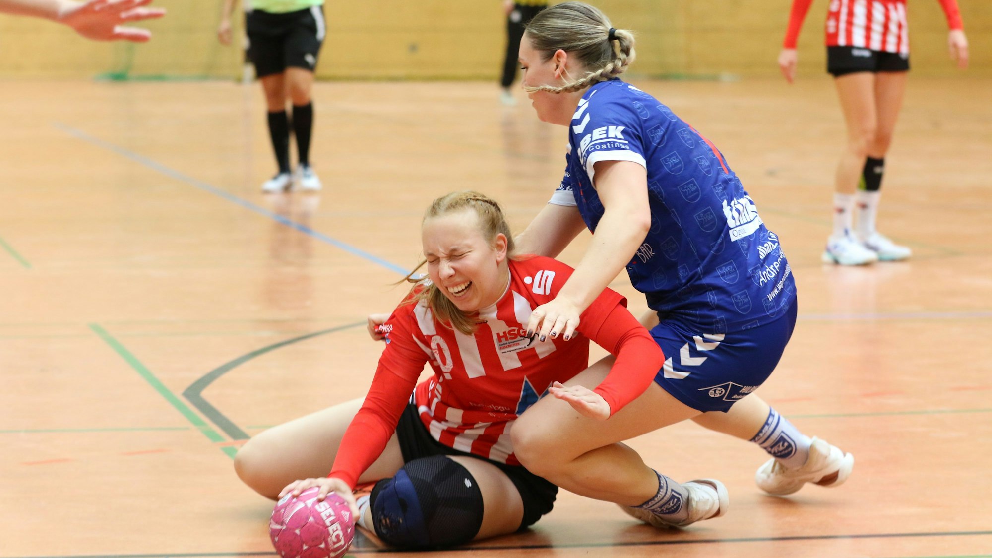 Die Euskirchenerin wird zu Boden gedrückt, ihr Gesicht ist schmerzverzerrt. Den Ball hat sie noch in der Hand. Ihre Gegnerin fällt ebenfalls.