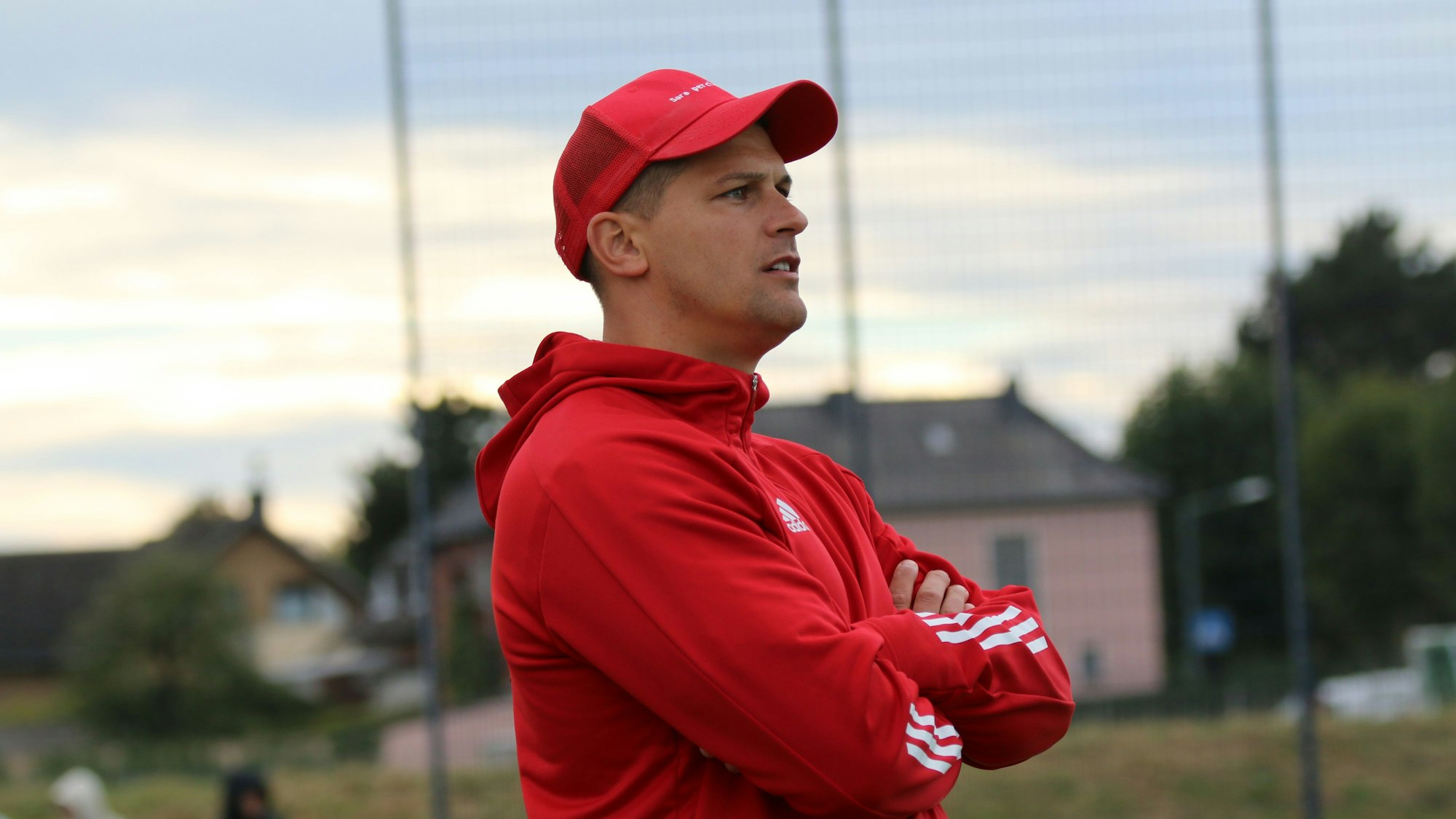 Der Trainer steht am Spielfeldrand und beobachtet die Begegnung.