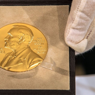 Eine Hand hält vor der Übergabe des Nobelpreises für Physik an den deutschen Physiker Genzel die goldene Medaille. (Archivbild)